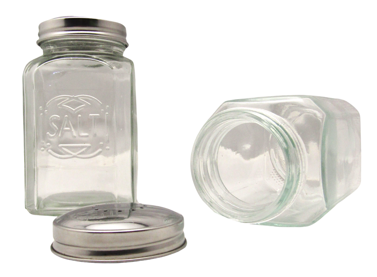 Clear glass salt and pepper shakers with metal lids, one standing upright and one lying on its side