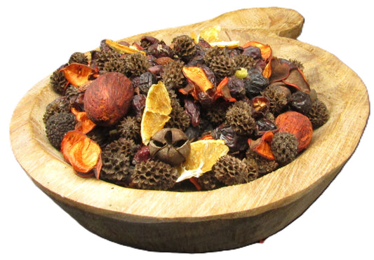 Wooden bowl filled with unique potpourri for home featuring dried fruits and natural elements