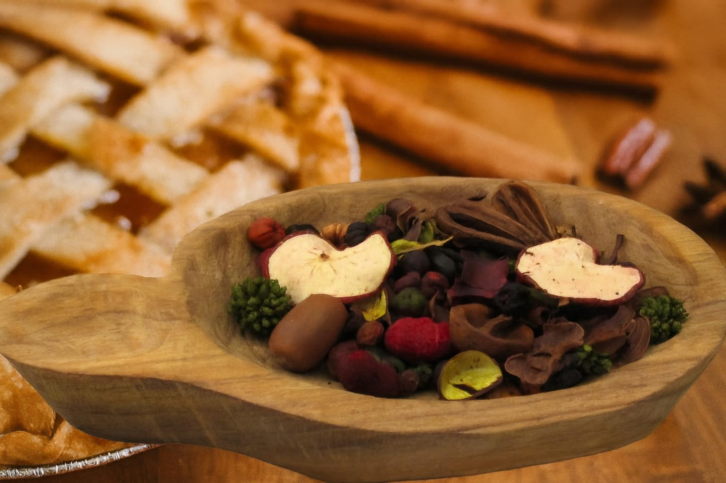 Baked apple pie potpourri in a wooden bowl, featuring dried fruits and spices for a cozy scent