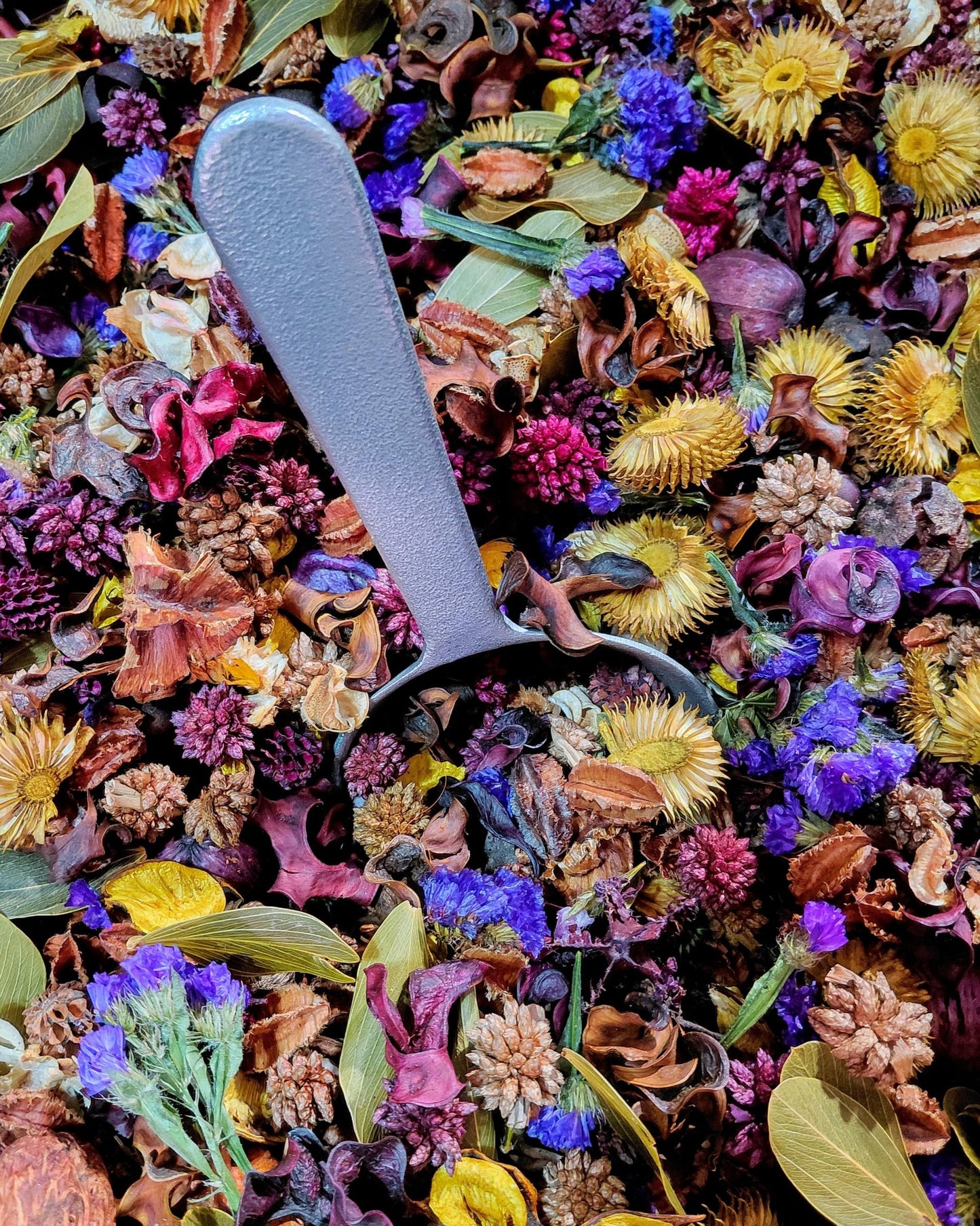 Colorful lemon lavender potpourri with dried flowers and a gray scoop for home fragrance