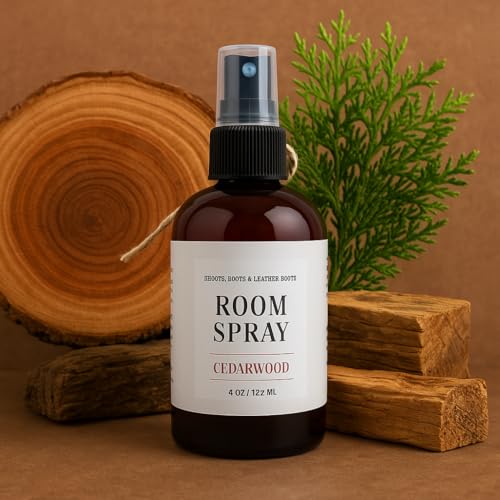 Shoots Roots Leather Boots cedarwood room spray in amber bottle with natural wood and green foliage background