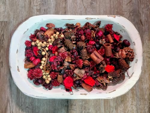 Cinnamon Potpourri in a rustic distressed white wooden tray with pinecones cinnamon sticks and red berries on wood floor