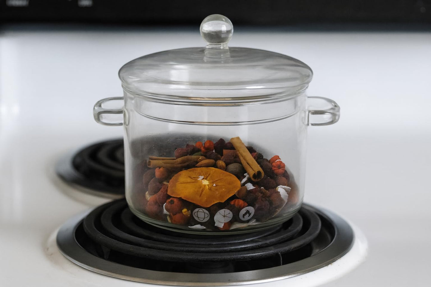 Glass stovetop pot with Pumpkin Spice Simmer Potpourri of dried orange cinnamon sticks and cloves