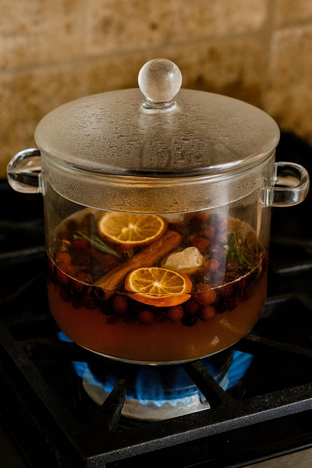 Simmer pot potpourri with refresher oil in a glass pot on the stovetop, featuring citrus and spices
