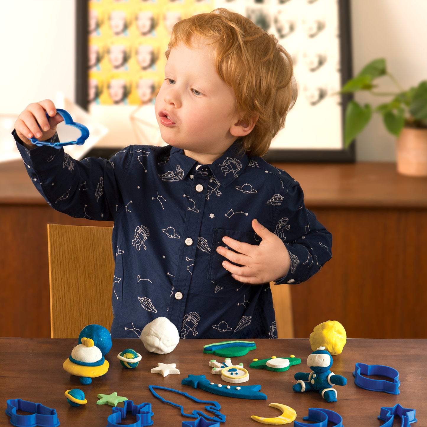 Child playing with Family Games America scented modeling dough kit using blue cutters and colorful dough shapes