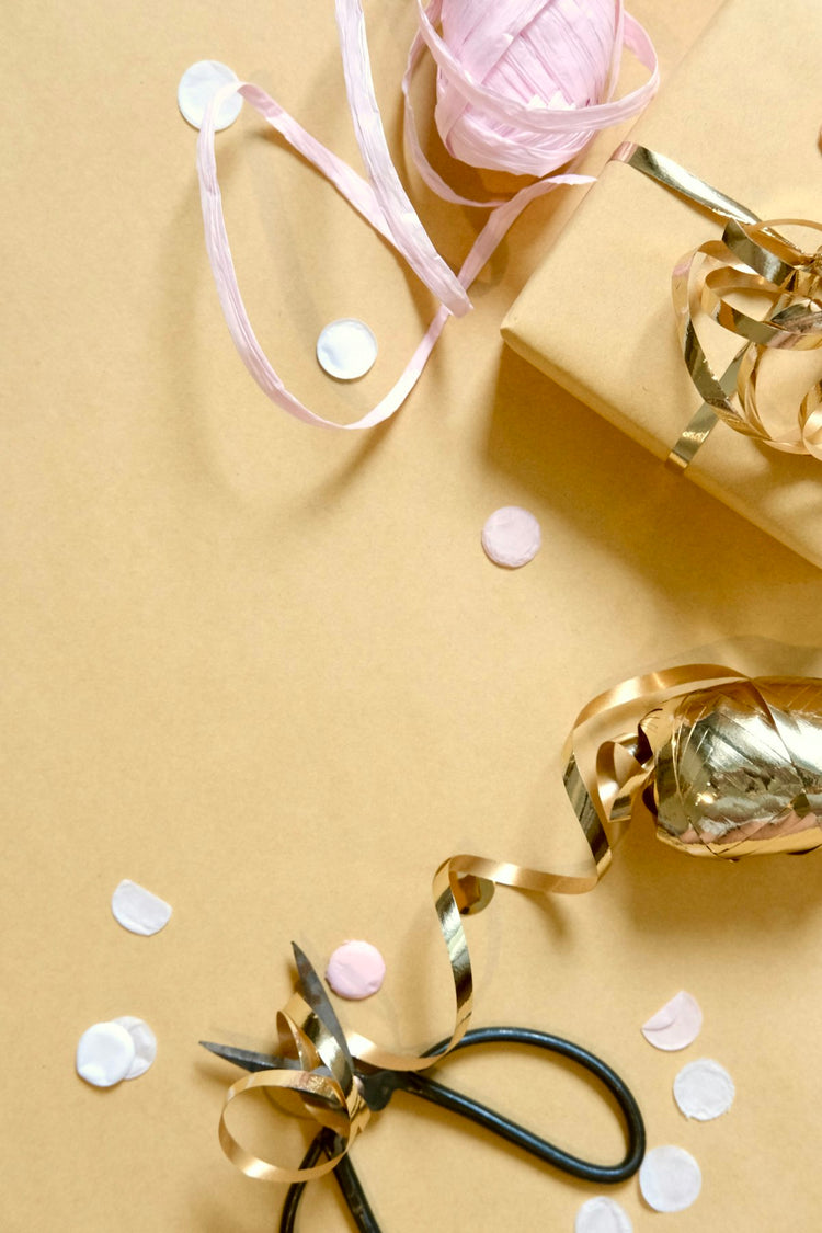 Gift wrapping supplies with scissors, ribbon, and confetti – thoughtful gift giving