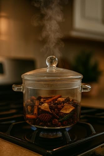 Glass pot with simmering apples and spice simmer fragrance oil surrounded by spices and herbs
