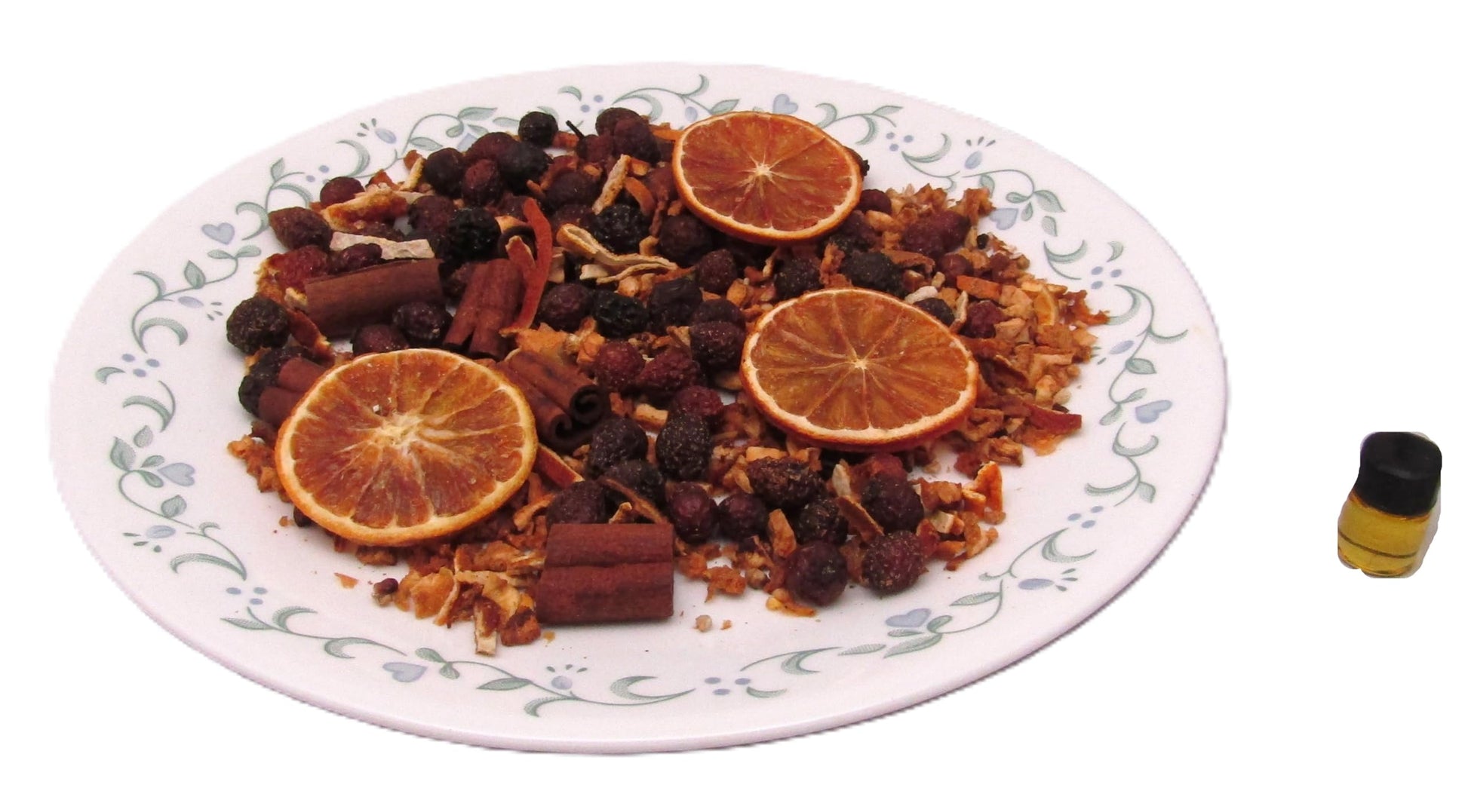 Cinnamon orange clove simmer potpourri mix arranged on a decorative plate with dried fruits and spices