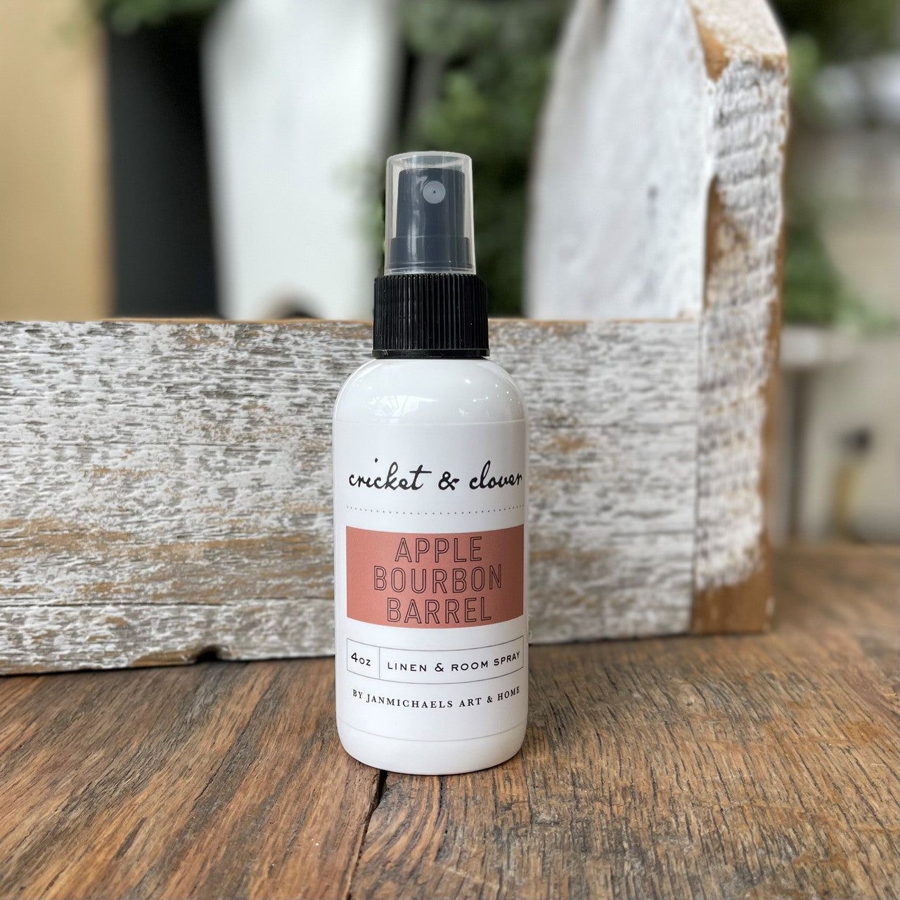 Cricket and Clover 4 oz linen and room spray bottle on wood labeled Apple Bourbon Barrel apple bourbon air freshener