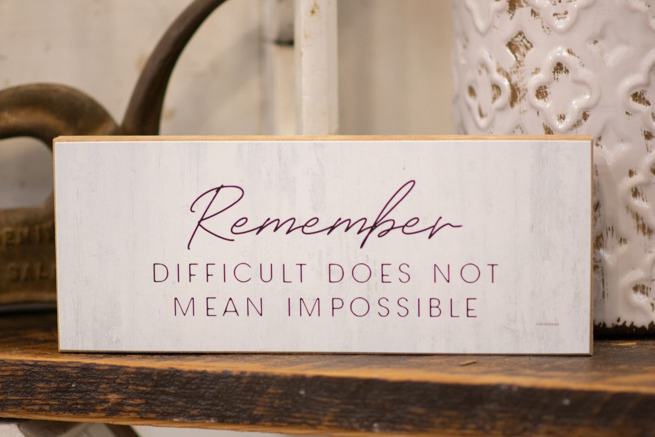Motivational wood block sign with the phrase Remember Difficult Does Not Mean Impossible for home decor