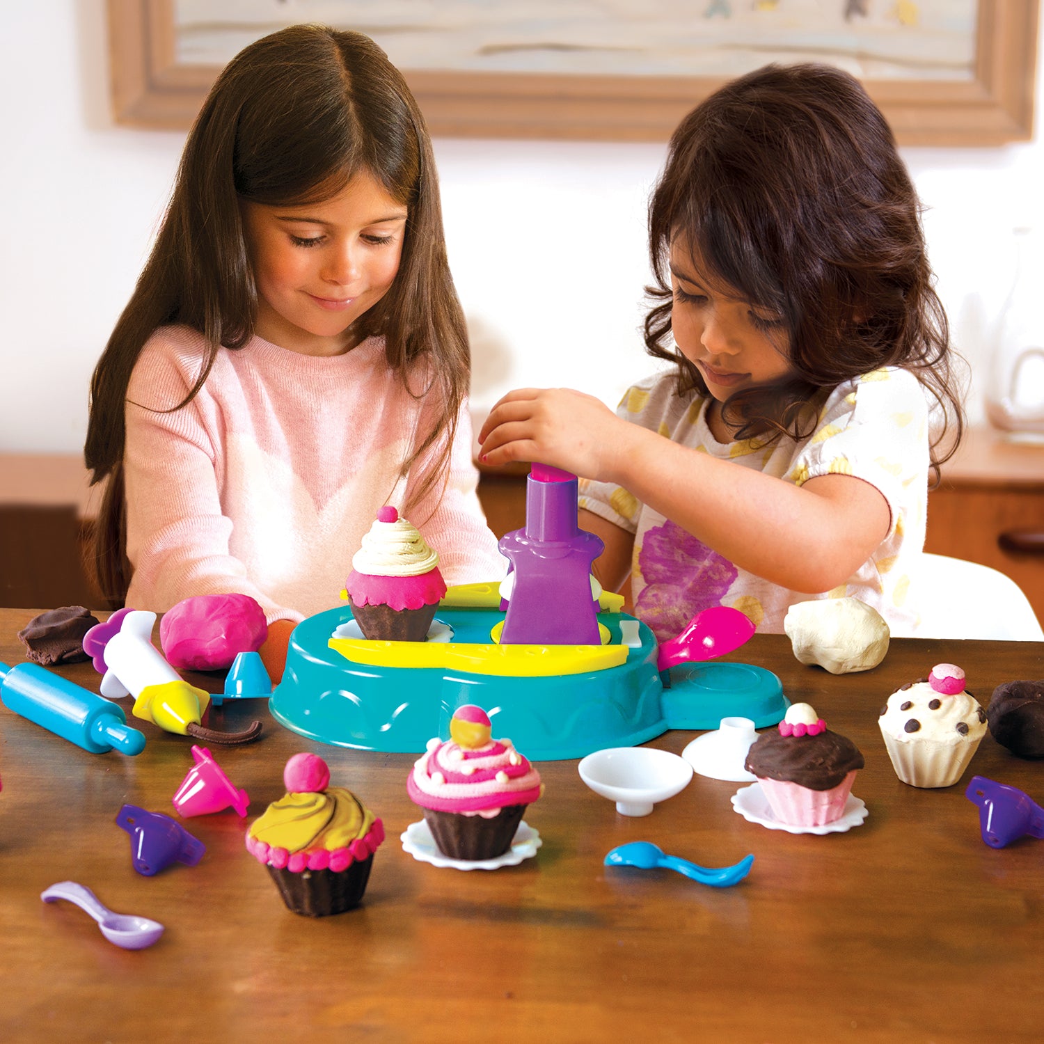 Two girls playing with Family Games America scented modeling dough kit creating colorful cupcakes and shapes