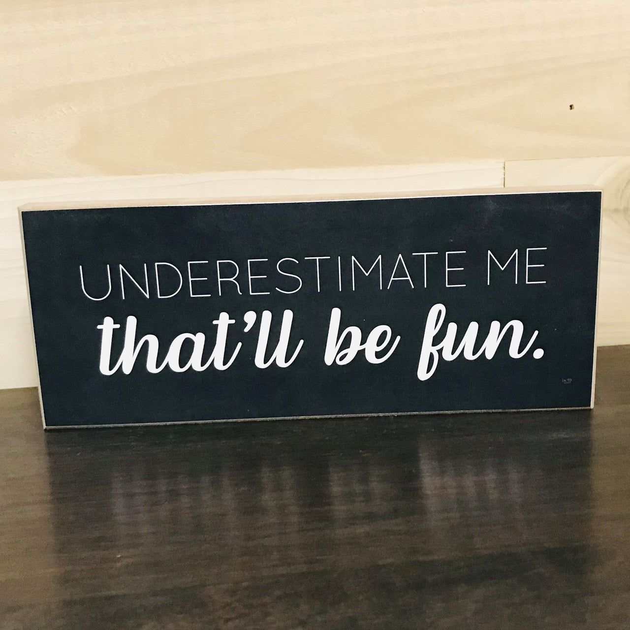 Jan Michaels Art & Home black wooden sign with white text reading underestimate me that will be fun sign