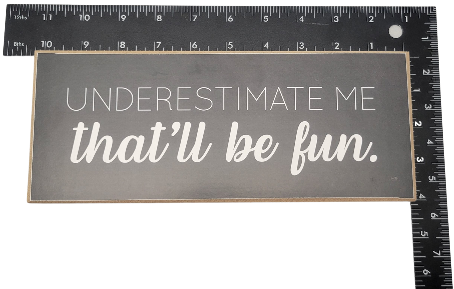 Underestimate me that will be fun sign in white text on black background home decor piece