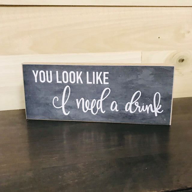 You look like i need a drink sign in white cursive and block letters on a dark gray wood plaque for home decor